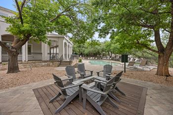 A patio with chairs and a table in front of a house.